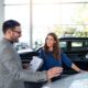 Cliente conversa sobre escolher um consórcio de carro em concessionária
