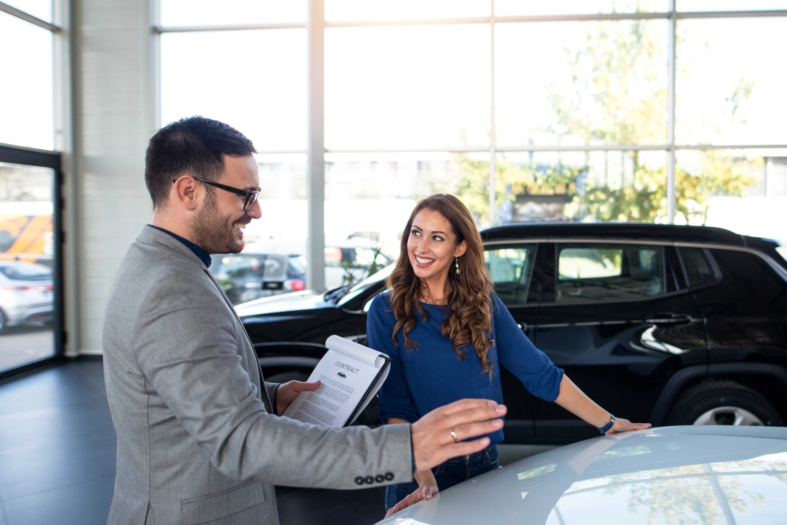 Cliente conversa sobre escolher um consórcio de carro em concessionária