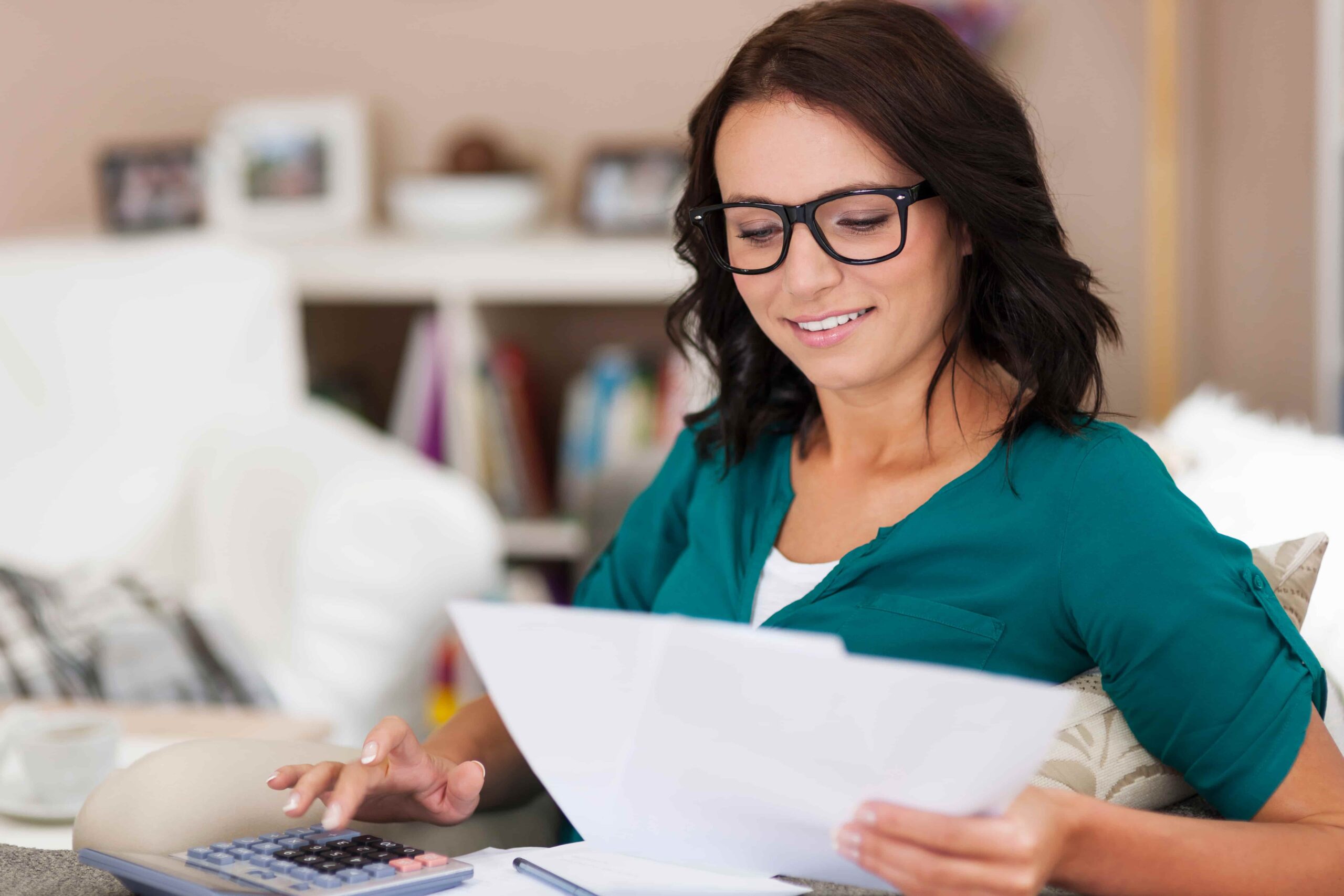 Mulher calcula o orçamento doméstico enquanto analisa as parcelas do consórcio